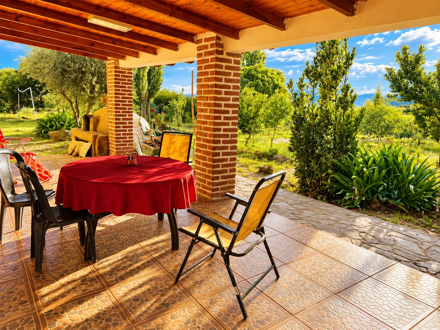 Galería de la finca, con mesa y vista al jardín